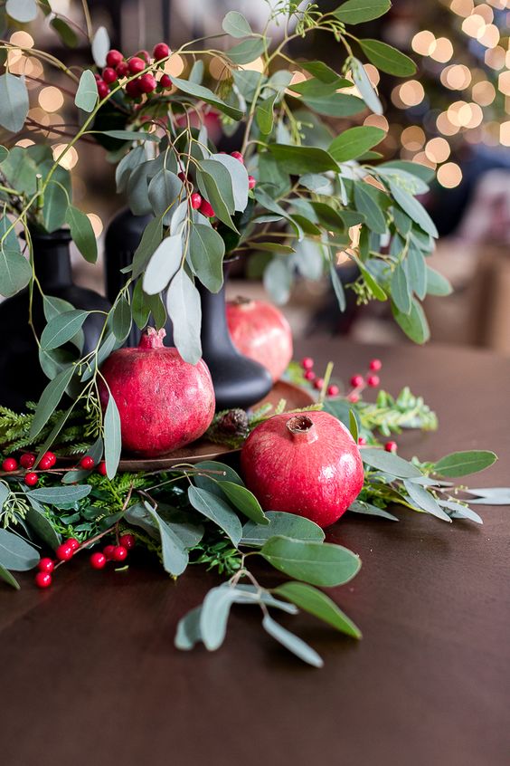 a bright and catchy centerpiece of greenery, berries and pomegranates will fit flal, winter or Christmas