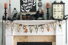 08 a vintage Halloween mantel with a bunting, blackbirds, orange candles, bars and vintage books and clocks