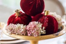 09 a bright fall or winter centerpiece of a bowl with blush hydrangeas and bold velvet pomegranates with rhinestones is super cool