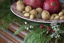 10 a catchy and simple centerpiece of nuts and pomegranates placed on evergreens is a lovely idea for fall or winter