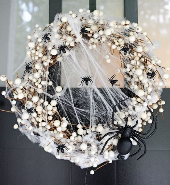 a stylish and scary Halloween wreath with lots of black spiders and a large one, realistic spiderweb and other stuff just wows