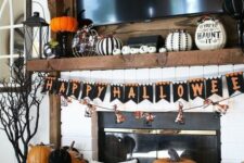 11 a bold and chic Halloween mantel with black and white pumpkins, a bright bunting and orange and black pumpkins
