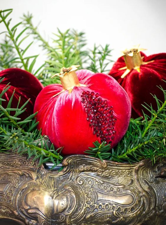 a catchy centerpiece of a large vintage bowl with evergreens and gorgeous velvet pomegranates with rhinestones will fit many parties