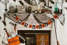 12 a colorful Halloween fireplace with a bold garland, lots of natural and faux pumpkins, printed pillows, black spider web, black bats on the wall