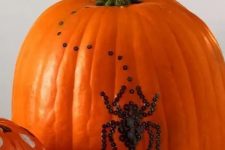 12 a natural orange pumpkin decorated with black sequins showing a spider is a beautiful and very cool idea that you can realize last minute