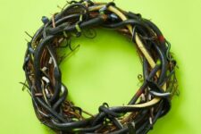 12 a scary Halloween wreath of vine interwoven with black and green faux snakes is a spooky and a veyr realistic decoration