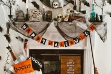 13 a colorful Halloween fireplace with a bold garland, lots of natural and faux pumpkins, printed pillows, black spider web, black bats on the wall