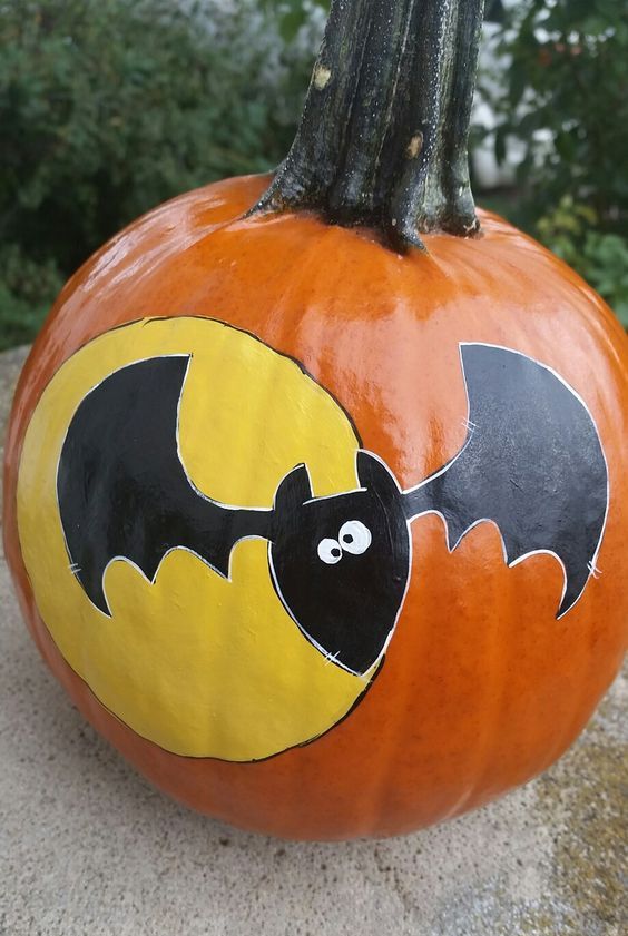 a funny painted Halloween pumpkin with a bat and a moon is a cool and pretty idea that won't take much time