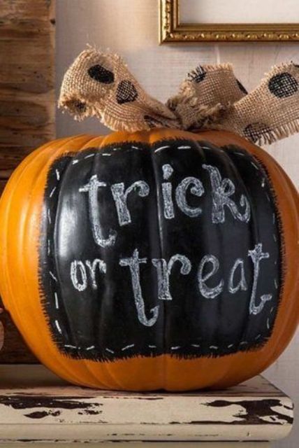 a Halloween pumpkin with a chalkboard touch and some chalk paint plus a burlap bow is a rustic decor idea