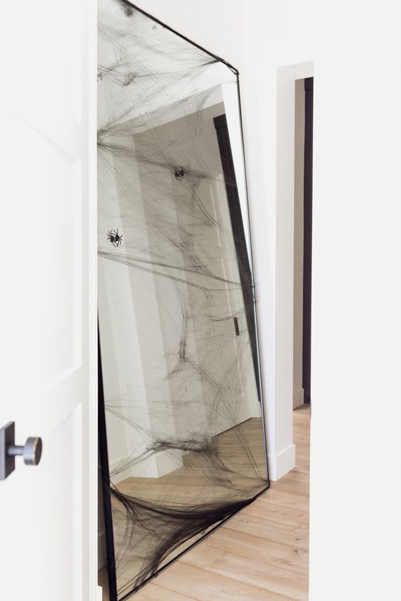 a large floor mirror with realistic spiders and spiderweb is a stylish solution for a modern Halloween space