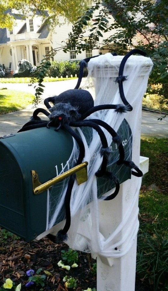 a black letter box on a pillar, with spiderweb and a large black spider is easy and fun Halloween decor that brings a Halloween feel