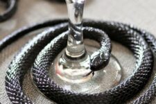 17 a black snake covering a glass is a lovely decor idea for styling your Halloween party table