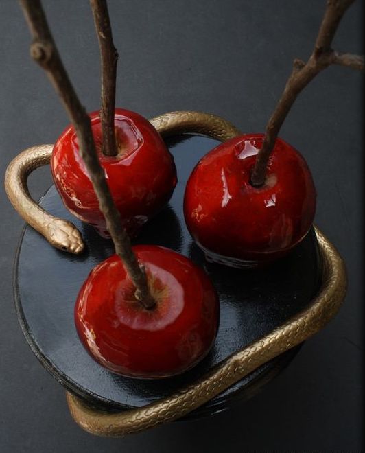 a black stand with a gold snake and candied apples on sticks is a cool idea for Halloween