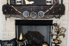 20 a sophisticated Halloween mantel with gold bats, gold skulls, pumpkins and candles, branches, a stand with lots of pumpkins