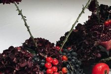 22 a moody centerpiece of tomatoes, a pomegranate, dark hydrangeas, grapes and dark dahlias is amazing for fall or Thanksgiving