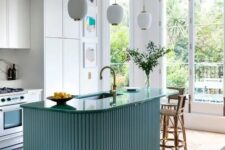 23 a beautiful modern kitchen with white cabinets, a blue fluted and curved kitchen island, pendant lamps and an eating zone