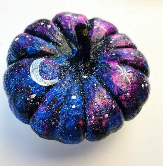 a small black, blue and hot pink pumpkin with white spot stars, large stars and moons for Halloween decor