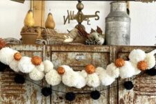 24 a black pompom and white pompom Halloween garland with little orange pumpkins is great not only for Halloween but also for the fall