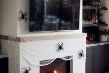24 a fireplace covered with faux spiderweb and black spiders, a couple of heirloom pumpkins is a gorgeous idea for Halloween