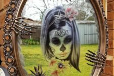 26 bold Halloween mirror decor with a sugar skull, skeleton hands and copper spiders is a cool and bright idea