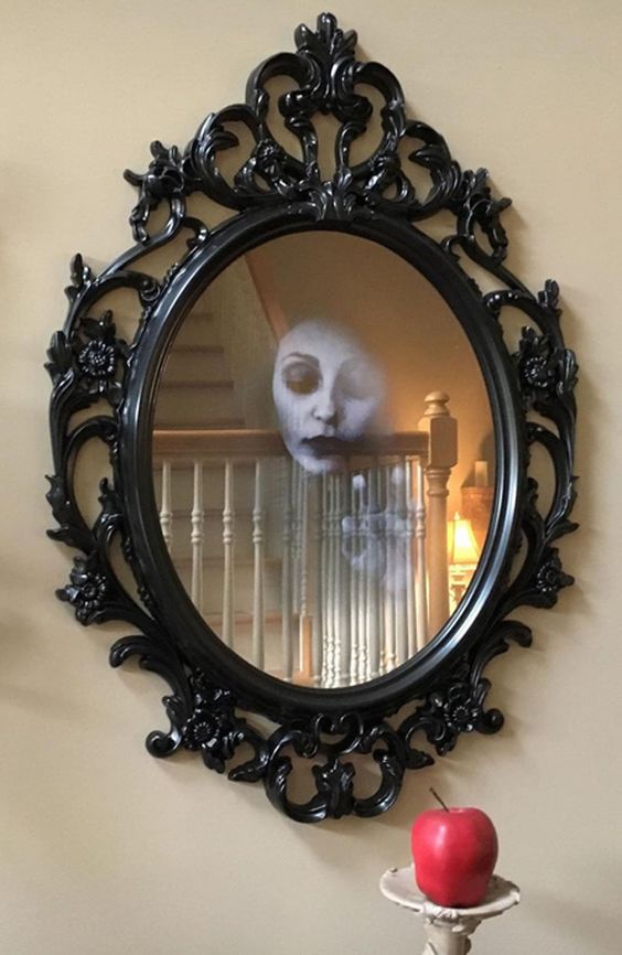 dramatic Halloween mirror decor with a ghost face inside it is a cool decoration for any Halloween space