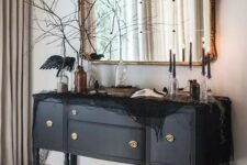 30 a beautiful black credenza decorated with black spider web, blackbirds, black candles and black branches is amazing