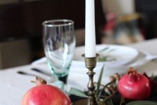30 a simple and pretty fall centerpiece of a table runner, greenery, pomegranates and plums plus a tall candle