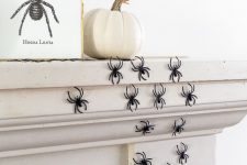 30 spiders climbing up the fireplace, a pumpkin and an artwork will give a Halloween feel to your space