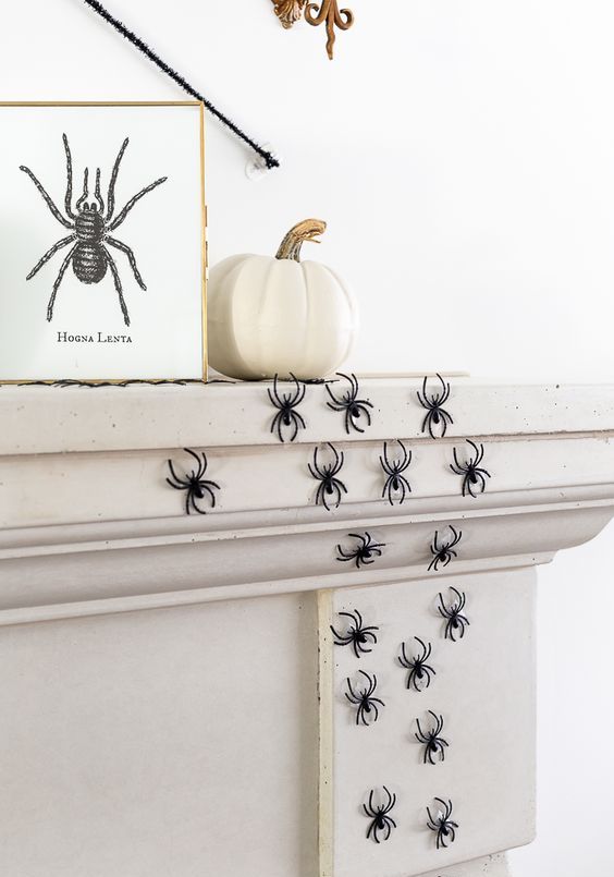spiders climbing up the fireplace, a pumpkin and an artwork will give a Halloween feel to your space