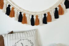 31 a creative boho Halloween garland of wooden beads, white, orange and black twine tassels is not difficult to make
