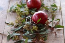 32 a table runner of seeded eucalyptus and pomegranates is a cool idea to style your table for fall or winter