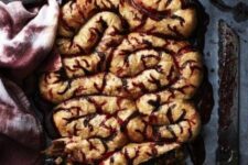 32 chorizo and caramelized onion stuffed intestines, which are pastry dough with cranberry sauce for Halloween