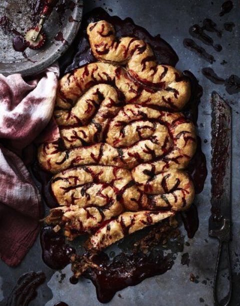 chorizo and caramelized onion stuffed intestines, which are pastry dough with cranberry sauce for Halloween
