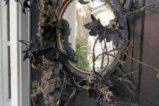 33 a black mirror with branches, twigs, black leaves and blackbirds is a lovely front door decoration for those who love vintage Halloween decor