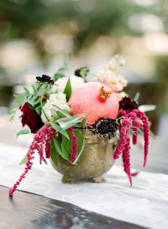 a vintage bowl with white, burgundy and deep purple blooms, greenery and a pomegranate is a lovely fall centerpiece you can compose yourself