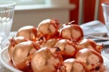 37 make a simple fall centerpiece of faux pomegranates and copper spray paint, that’s an easy and glam solution