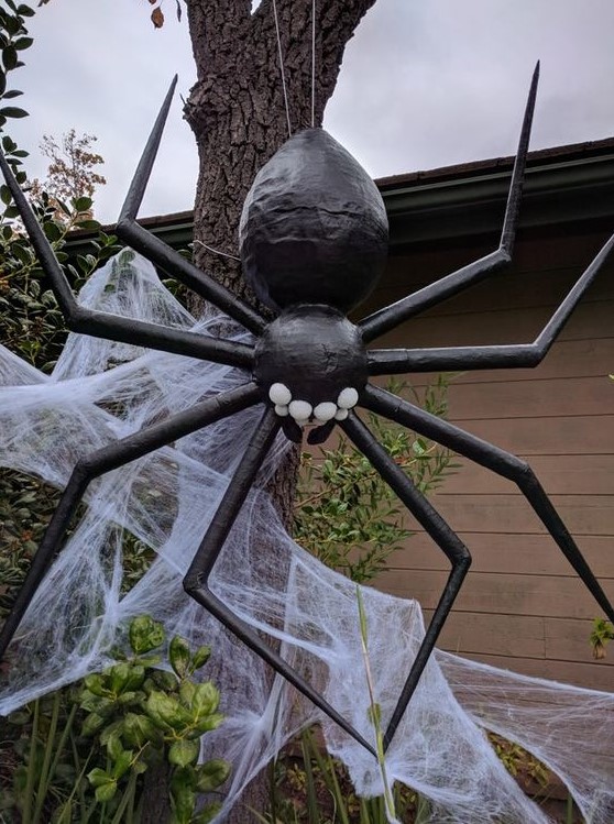 a giant black spider with realistic spiderweb is a stylish and scary idea to decorate your outdoor or even indoor space and it wows