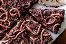 39 layers of dark chocolate mousse, chocolate pecan cookie dirt and chocolate whipped cream are topped with realistic raspberry gummy worms to make a frightfully delicious Halloween dessert