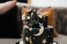 41 a black celestial Halloween cake with gold stars and moons, a black snake and butterflies is great for the party
