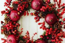 41 a bold abd catchy wreath for fall or Christmas made of pomegranates, berries, mini apples and pinecones