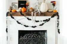 41 a lovely Halloween fireplace with stacked pumpkins, black bat buntings, pumpkins and a skeleton on the mantel and black balloon letters
