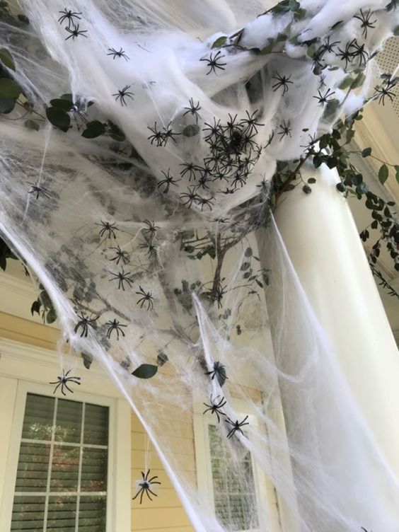 cover your porch with cheesecloth and spiders to make it Halloween-like and bold
