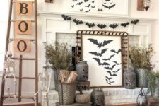 45 a rustic Halloween mantel with lots of bats, dried branches, jack-o-lanterns, skeletons, a ladder with letters