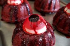 45 red velvet cakes with eyeballs on top and some chocolate sauce are great as Halloween desserts