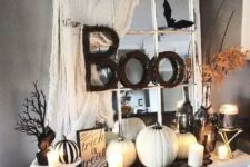 46 vintage Halloween decor in black and white, with a vintage mirror, some spiderweb, white pumpkins and candles, leaves and branches