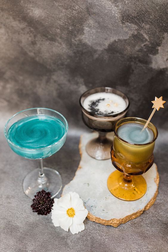 Lovely Halloween celestial cocktails in turquoise color, with a moon and star shaped stirrers