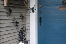 51 paper spiders on the walls, black and white pumpkins, a spiderweb wreath and a sign for simple and fast Halloween decor
