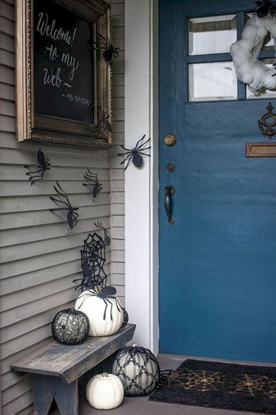 paper spiders on the walls, black and white pumpkins, a spiderweb wreath and a sign for simple and fast Halloween decor