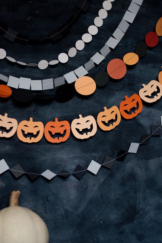 An arrangement of Hallwoeen paper garlands with rhombs, polka dots, squares and jack o lanterns