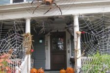 54 spiderwebs wtih large spiders and carved pumpkins create a stunning Halloween look for the front porch